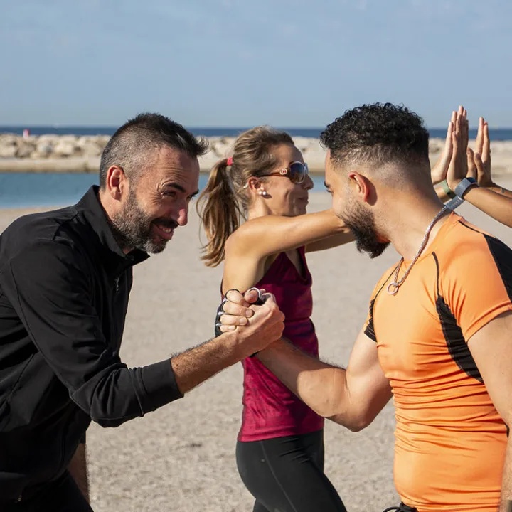 Participants Urban Training qui se saluent avant une séance de coaching collectif aux plages du Prado, à Marseille